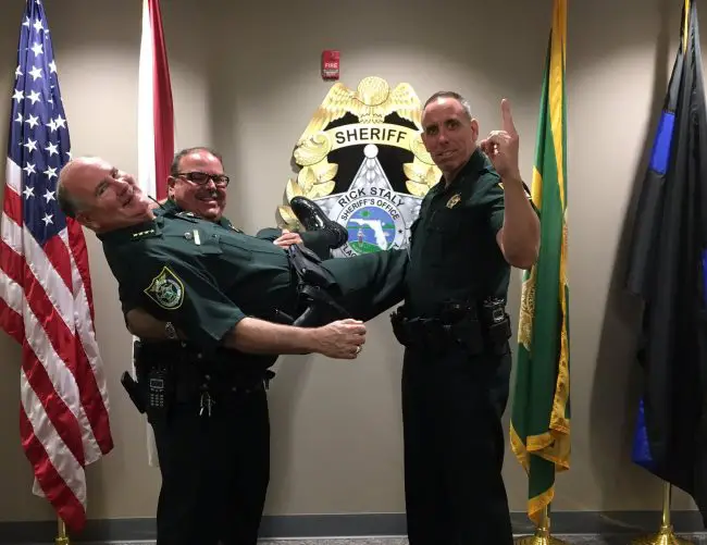 Cmdrs. Jeff Stuart and Paul Bovino hold up Sheriff Rick Staly on Bosses' Day this week. (FCSO)