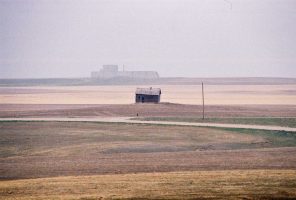 The unfinished, colossal PAR site--Perimeter Acquisition Radar--in the distance on the Montana prairie, one of the most massive buildings in the state, even in unfinished form, one of its most absurd, and one of the remarkable monuments to cold war futility on the planet. It's near Ledger, Montana. (© FlaglerLive)