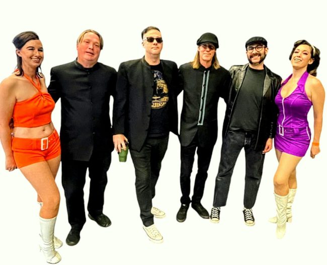 Flanked by Los Angeles-based go-go dancers Meghan Morgan, left, and Miss Magnolia, right, the pop-rock band the Cherry Drops includes, from left: drummer Jimmy Mason, bassist Jamie Markowski, singer Vern Shank and guitarist Josh Cobb. (Vern Shank)