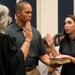 County Judge Melissa Distler swears in Christy Chong with the new school board member's husband, Kirk Chong, at her side, this morning. (Flagler Schools)