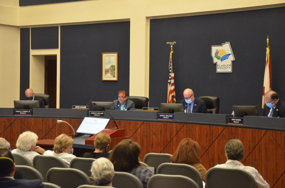 Commissioners Don O'Brien and Dave Sullivan flanked Joe Mullins Monday night. (© FlaglerLive)