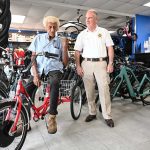 Francisco Diaz, who turns 80 next month, is back on a brand new bike after his porevious bike was totaled in a crash with a car on State Road 100, when Sheriff Rick Staly, right, responded, and helped organize a fund-raiser to get Diaz back on his wheels. (© FlaglerLive)