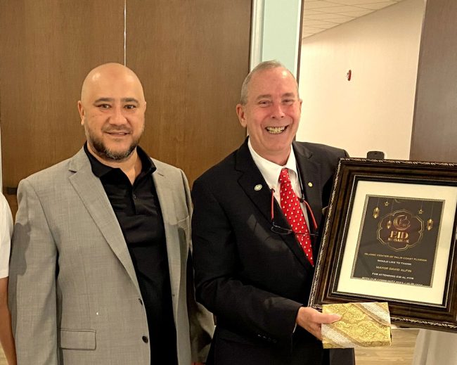 Islamic Center of Palm Coast president Shuhrat Yosin presents Palm Coast Mayor David Alfin with a plaque commemorating his attendance of Eid. (© FlaglerLive)