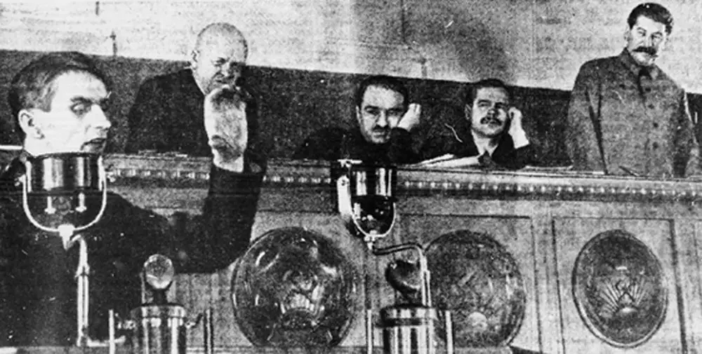 Trofim Lysenko, left, speaking at the Kremlin in 1935, with Joseph Stalin standing, right. (Wikimedia Commons)