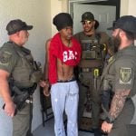 Deputies arresting Micah McGill, partially wearing the Gap shirt, at his home in Palm Coast on Tuesday. (FCSO)