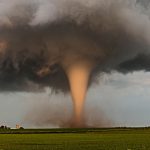 A tornado churns up dust in the sunset light near Traer, Iowa by Brad Goddard, Orion, Ill. (NOAA)