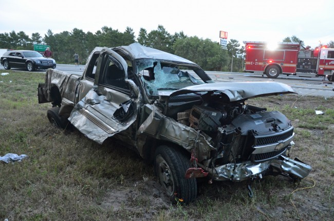 The pick-up truck jumped the guard-rail, ejecting a passenger, and crashing into a sedan. Click on the image for larger view. (© FlaglerLive)