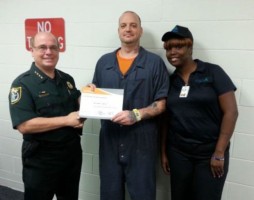 Inmate Christopher Avellar, 32, receives his food certificate of achievement as Sheriff James L. Manfre, left, and    food supervisor Paula McNeal congratulate him.