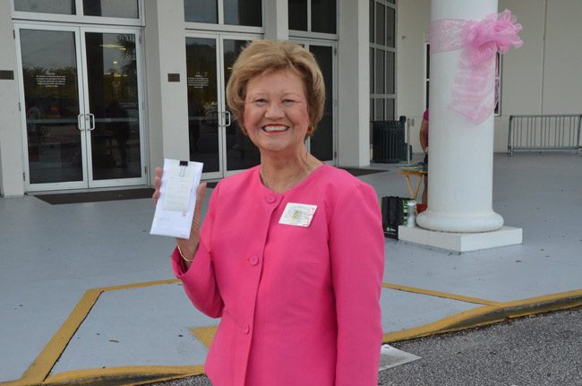Flagler County Tax Collector Suzanne Johnston holds up her office's latest gift for the Flagler Youth Orchestra, a collection of $1,042 from tip jars left around the collector's office for voluntary donations. Johnston has been a long-time friend of the orchestra. (c FlaglerLive)