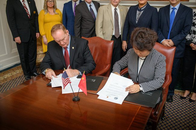 Flagler College President Joseph G. Joyner signs the agreement with CFAU Vice President LI Hongmei in the President’s Board Room in Ponce de Leon Hall at Flagler College on Monday. (Flagler College)