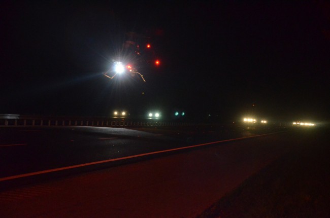 Volusia's Air One emergency helicopter approaching its landing zone on the northbound lanes of I-95, as southbound traffic continued unimpeded. Air One had to be called in because budget constraints prevent Flagler County's Fire Flight from being used past 8 p.m., most days, though it was on until 10 p.m. Friday. The wreck took place at 10:30 p.m. Click on the image for larger view. (© FlaglerLive)