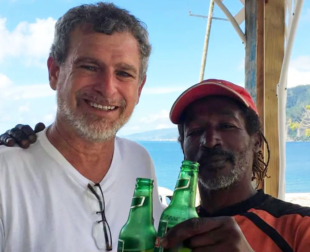 The picture at the center of a controversial television commercial produced by Milissa Holland's campaign, showing candidate Alan Lowe, left, and Philip, a resident of Dominica, in 2017, after Philip survived drowning in waters churned by Hurricane Maria according to Lowe. (Alan Lowe)