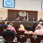 Palm Coast Mayor David Alfin, center on the dais, this evening did not use a prop to defend the budget he moved to adopt, as he spoke against disinformation, an allusion to electioneering and false claims he sees driving opposition to the city's budget. (© FlaglerLive)