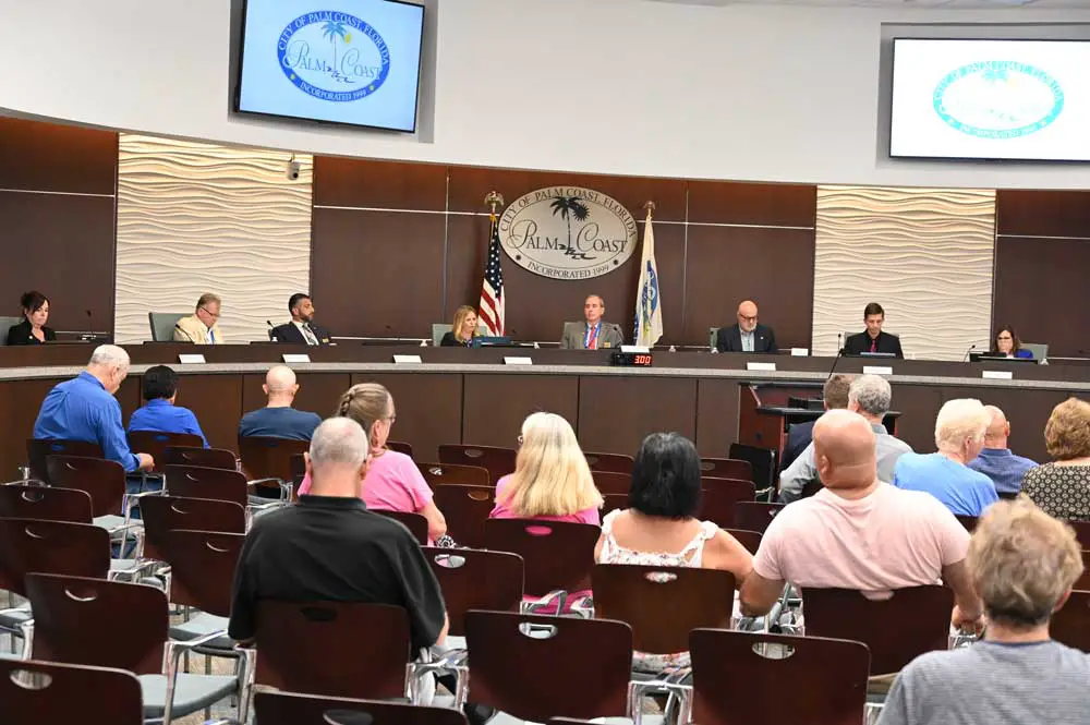 Palm Coast Mayor David Alfin, center on the dais, this evening did not use a prop to defend the budget he moved to adopt, as he spoke against disinformation, an allusion to electioneering and false claims he sees driving opposition to the city's budget. (© FlaglerLive)