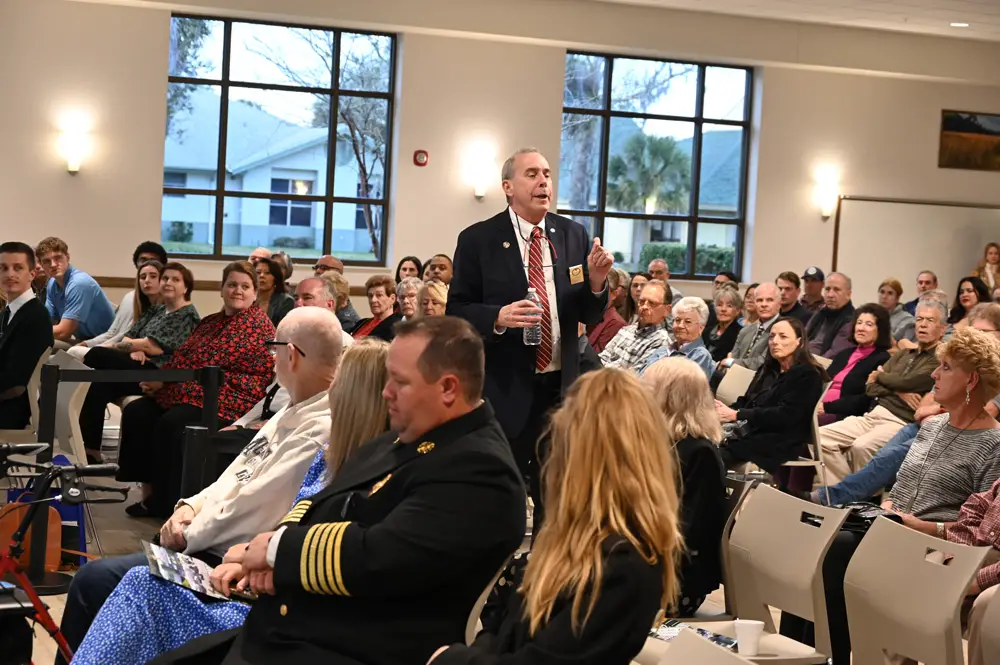 Palm Coast Mayor David Alfin went into the crowd of more than 200 at this evening's State of the State address for a little preamble. (© FlaglerLive)
