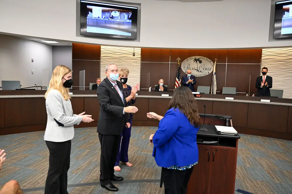 Palm Coast Mayor David Alfin immediately after his swearing in, acknowledging City Clerk Virginia Smith, with his daughter Melanie and his wife Tammy at his side, and the council he was about to join behind him--with some on the dais more enthusiastic than others about his accession. (© FlaglerLive)
