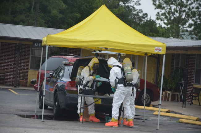 The Hazmat team analyzing samples next to a Bunnell city police cruiser in mid-afternoon. (c FlaglerLive)