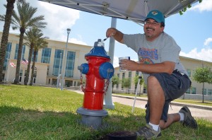 School Board Chairman Andy Dance transforming the hydrant in front of the county courthouse. Click on the image for larger view. (© FlaglerLive)