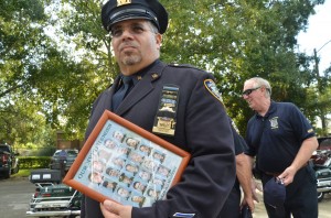 Retired New York City cop Anselmo Santoni clutched a framed montage of the 23 New York City cops killed on 9/11. An additional 37 Port Authority cops were also killed. Click on the image for larger view. (© FlaglerLive)