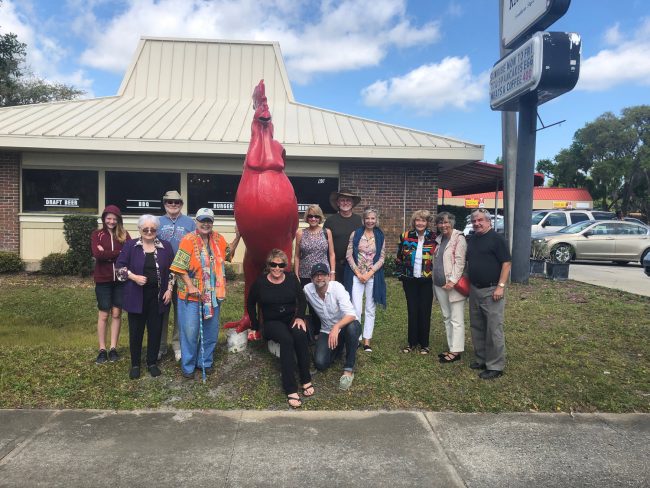 After today's ceremony all the artists headed to the Chicken Pantry in Bunnell, then posed for this shot by the red rooster, another kind of public art. (© JJ Graham for FlaglerLive)