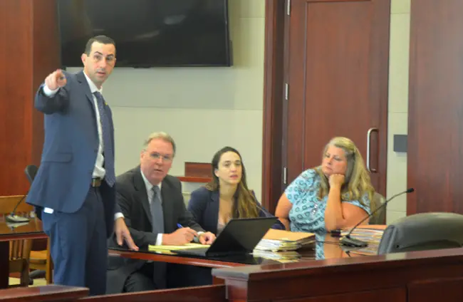 Assistant State Attorney Jason lewis, standing, with the attorneys for the defense, Kevin Kulik and Ashley, seated next to Kimberle Weeks, in blue, at today's jury selection. (c FlaglerLive)