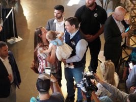 Ron DeSantis is handed a child by a parent attending his speech at Sun Valley Barn in Pella, Iowa, on May 31, 2023. He would win 21.3% of the vote in the Iowa caucuses. (Photo by Robin Opsahl/Iowa Capital Dispatch)