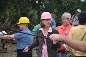 A hard-hatted, and curiously color-coordinated, Commissioner Barbara Revels, moments before the tear-down of the billboard. Click on the image for larger view. (© FlaglerLive)