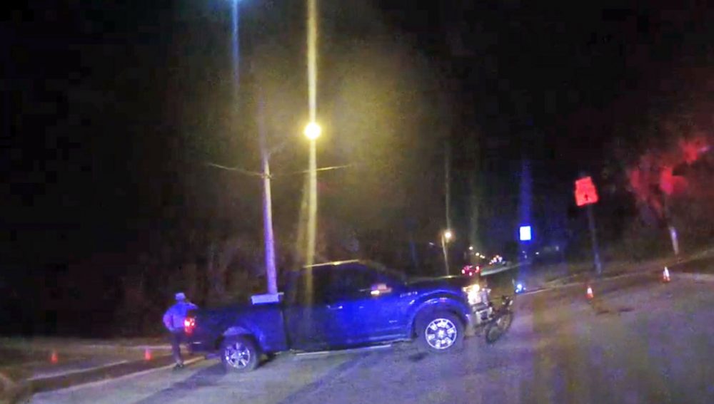 Flagler Beach Commissioner Rick Belhumeur speaks on his cell phone by his truck, the cyclist's bicycle stuck to the front of the vehicle, in a screen capture from a deputy's body camera. The cyclist by then had been transported to Halifax hospital. 