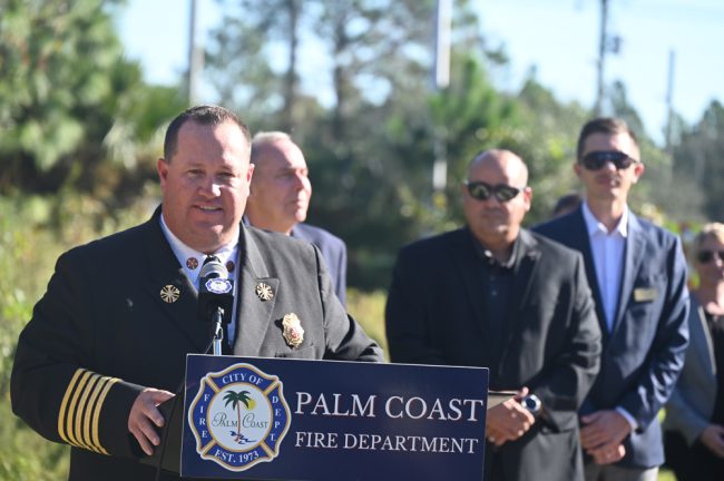 "The most important part of what we're celebrating today is those citizens and their trust in our city and our fire department," Palm Coast Fire Chief Kyle Berryhill told the assembled at today's groundbreaking. Four City Council members were there, in the background, from left: Mayor David Alfin and council members Charles Gambaro, Nick Klufas and Theresa Pontieri. (© FlaglerLive)