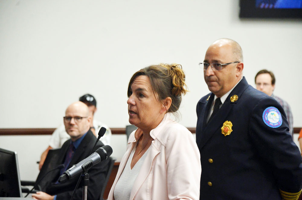 Denis Bevan, standing at the podium with Palm Coast Fire Chief, as the Palm Coast City Council was offering her the interim manager's job last Tuesday. (© FlaglerLive)