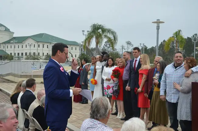 Clerk of Court Tom Bexley, left, preparing to marry 16 couples at last year's Valentine's Day ceremony on the courthouse steps. (© FlaglerLive)