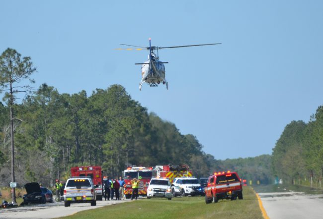 Flagler County Fire Flight, the emergency helicopetr, lifts off from the southbound lanes of U.S. 1, north of Matanzas Woods Parkway, with one of the men seriously injured in a crash with the driver of a car at around 3:35 this afternoon. Click on the image for larger view. (c FlaglerLive)