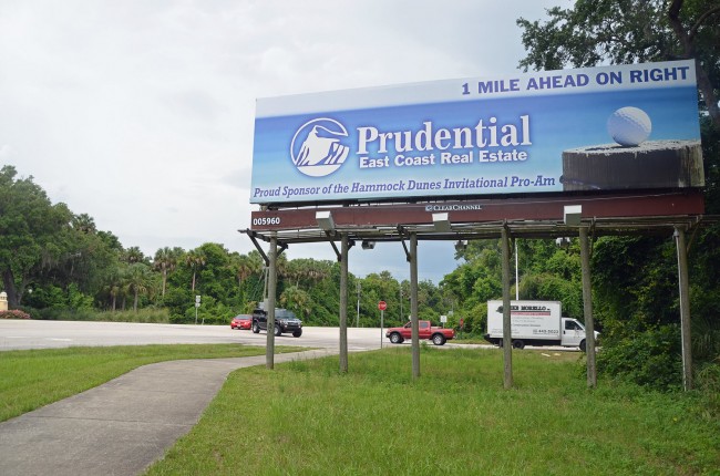 The familiar, double-sided billboard at the intersection of A1A and Camino del Mar, the road that leads to the Hammock Dunes Bridge. Click on the image for larger view. (© FlaglerLive)