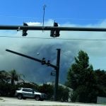 Slow dark billows of smoke darkened portions of an otherwise blue sky, as seen from Palm Coast's L Section this afternoon. The smoke is from a controlled burn at Faver-Dykes State Park across the Flagler-St. Johns county line. (© FlaglerLive)