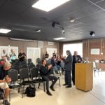 Flagler Beach Police Chief Lance Blanchette acknowledging a standing ovation at this evening's City Commission meeting after City Manager Dale Martin, at the lectern, formally announced his appointment as Matt Doughney's successor. (© FlaglerLive)