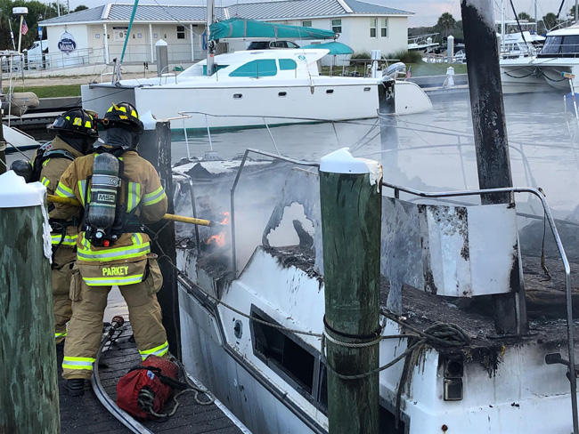 Flagler County firefighters battling the blaze on one of the two boats this afternoon in Marineland. (Flagler Professional Firefighters Firefighters)