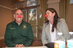 Yes, they all put on the red noses, to end the evening 'on a positive,' in Colleen Conklin's words. Above, the Flagler County Sheriff's Chief Paul Bovino and Palm Coast Mayor Milissa Holland, who not long before had told the wrenching story of her mother's suicide. Click on the image for larger view. (© FlaglerLive)