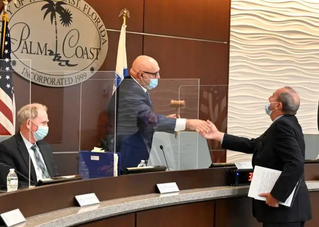 Councilman Eddie Branquinho welcoming newly sworn-in Mayor David Alfin to the council last August. They're still cordial, but Branquinho is signaling he may challenge Alfin in two years. (© FlaglerLive)