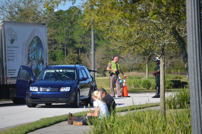 The vehicle involved in the wreck in Town Center Monday morning, next to an Austin Outdoors truck. The mower that was also involved is behind the truck. (© FlaglerLive)