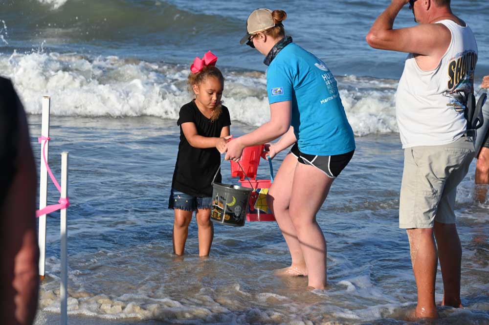 A young girl lent her play buckets to the effort. (© FlaglerLive)