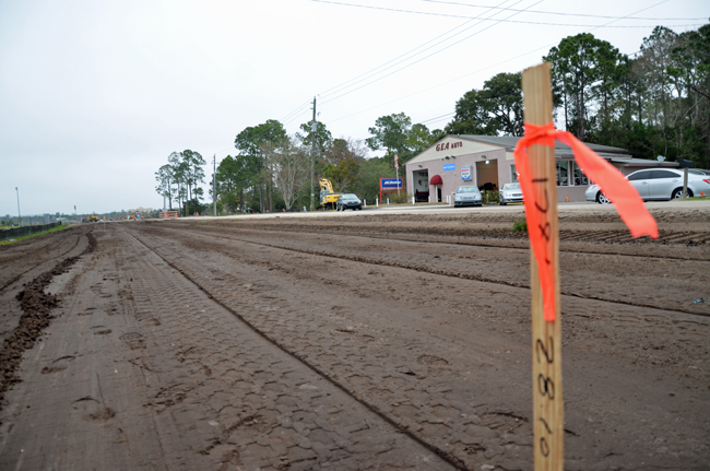 Palm Coast has staked a claim on Bulldog Drive even though since the right-of-way has been county property, never ceded to the city. Gus Ajram's GEA Auto business is in the near distance, and has been at the center of a long battle with the city. (© FlaglerLive)