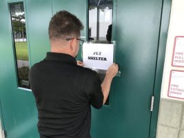 Marcus Sanfilippo posts one of the most essential notices under the sheltering sky at Bunnell Elementary. (Jason Wheeler/Flagler Schools)
