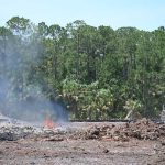 A wood pile burning in May at the site of a development for over 300 homes along Royal Palms Parkway in Palm Coast. The burning there has stopped. (© FlaglerLive)