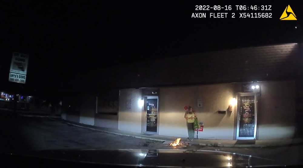 An image from the dash cam of a law enforcement officer who drove up to the parking lot of Larry's Guns in Bunnell at 2 a.m. Tuesday, as a woman was burning belongings in front of the store. 