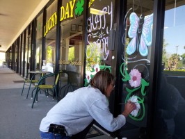 'They should leave them be. They’re not hurting anybody,' says Wendy Carson as she decorated the outside of Lucky Day, the cafe in the Winn Dixie shopping center along State Road 100 in Palm Coast. Click on the image for larger view. (© FlaglerLive)