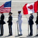 An honour guard stands with U.S. and Canadian flags in July 2024 as they wait for Canadian Prime Minister Justin Trudeau to arrive at Andrews Air Force Base, Md., to attend the NATO summit in Washington.