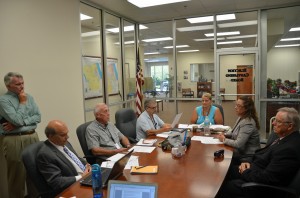 Today's Canvassing Board meeting. From left, County Attorney All Hadeed, Palm Coast City Council member Dave Ferguson (standing), County Commissioner Charlie Ericksen (an alternate member of the Canvassing Board), County Commission Chairman George Hanns, Supervisor of Elections Kimberle Weeks, County Judge Melissa Moore-Stens, whio chairs the board, and City Council member Bill McGuire. Virginia Smith, the Palm Coast City Clerk, was to the right of Ferguson. Click on the image for larger view. (© FlaglerLive)