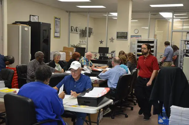 The Flagler Canvassing Board and election workers going through the 7,000-some mailed-in ballots that arrived today. It's a mid-term election, but the turnout numbers seem more like those of a general election. (© FlaglerLive)