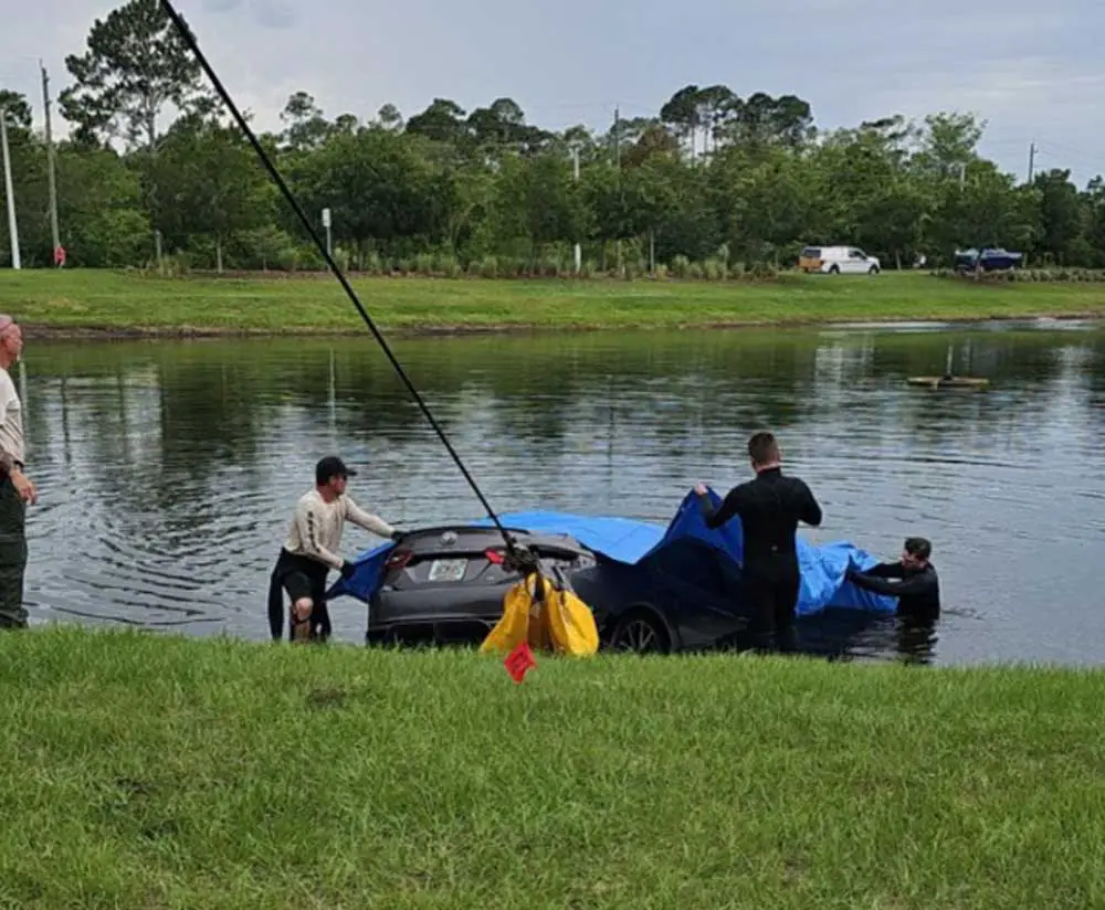 The rental car being pulled out of the pond late this afternoon. Its occupant was pronounced deceased at 5 p.m. (© FlaglerLive)