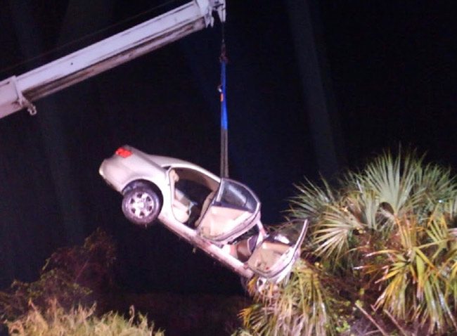 The victim's car being lifted by a crane last night: John's Towing of Bunnell pulled the car out of a 15-foot deep canal. (© FlaglerLive)